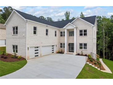 Stunning two-story home with a white brick facade, large windows, and a spacious three-car garage at 4267 Matisse Ln, Fairburn, GA 30213