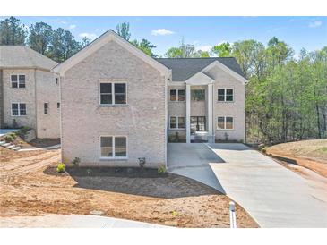 Stunning two-story home with a white brick exterior and a long private driveway at 4267 Matisse Ln, Fairburn, GA 30213