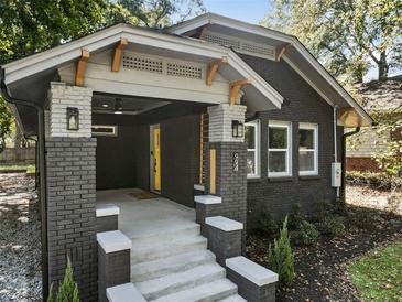 Brick home with a covered porch, steps, and landscaping at 994 Byron Sw Dr, Atlanta, GA 30310