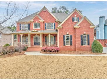 Brick two-story house with front porch and landscaped lawn at 6037 Addington Nw Dr, Acworth, GA 30101