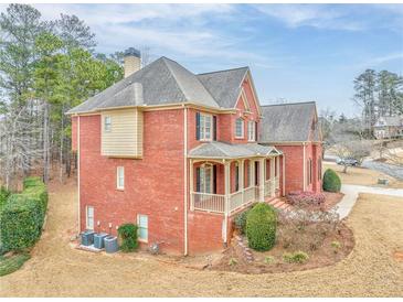 Brick house with front porch, landscaping, and driveway at 6037 Addington Nw Dr, Acworth, GA 30101