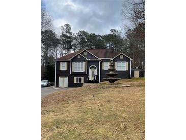 House exterior featuring a two-car driveway and a landscaped lawn at 103 Live Oak Ct, Dallas, GA 30157