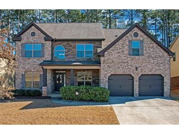 Brick two-story house with a large driveway and landscaping at 11850 Markham Way, Hampton, GA 30228