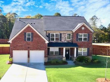 Two-story brick home with a two-car garage and manicured lawn at 799 Blue Juniper Cir, Loganville, GA 30052