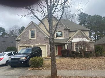 Brick two-story house with a two-car garage and a manicured lawn at 7981 Gossamer Dr, Fairburn, GA 30213