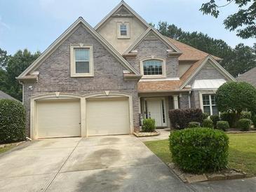 Charming two-story home with a brick facade, a two-car garage, and well-maintained landscaping at 7981 Gossamer Dr, Fairburn, GA 30213