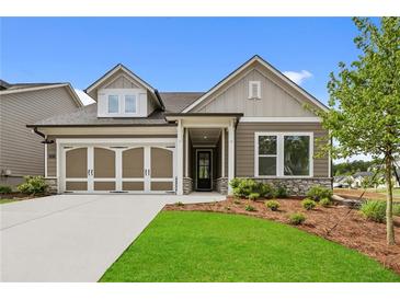Charming single-Gathering home with a two-car garage, stone accents, manicured lawn and inviting covered entry at 2012 Ripple Park Bnd, Canton, GA 30114