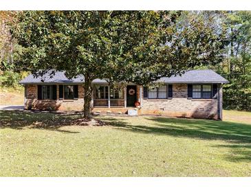 Brick ranch house with mature trees and a well-maintained lawn at 1167 Mcclung Rd, Hiram, GA 30141