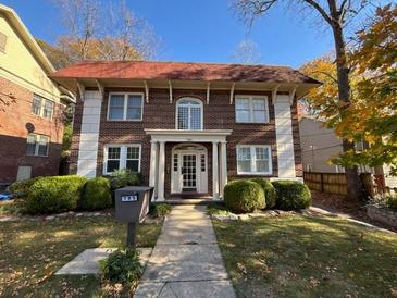 Brick two-story home with a red roof, white columns, and manicured lawn at 785 Ponce De Leon Ne Pl # 8, Atlanta, GA 30306