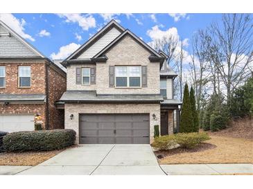 Two-story brick home with attached garage and landscaping at 8775 Village Pl, Suwanee, GA 30024