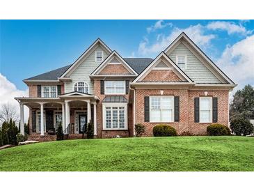 Brick two-story house with a large front yard and landscaping at 2057 Chambord Way, Snellville, GA 30078