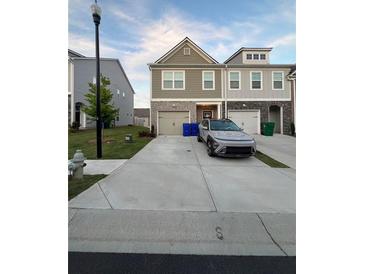 Two-story townhome with attached garage and driveway at 1887 Plainsboro Dr, Lithonia, GA 30058