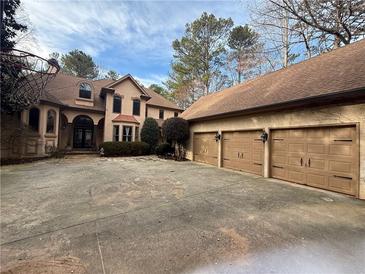 Elegant home features a three-car garage, basketball hoop, and a spacious driveway at 5041 Towne Lake N Hls, Woodstock, GA 30189