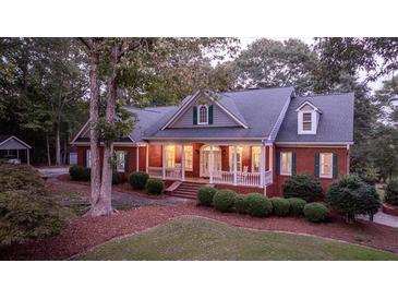 Brick house with front porch and landscaped yard at 992 Pj East Rd, Covington, GA 30014