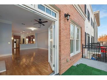 Spacious living room featuring hardwood floors, ceiling fan, and an open layout into kitchen area at 340 Town Center Ave # 215, Suwanee, GA 30024