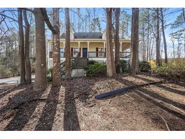 Charming home with a front porch surrounded by trees creating a tranquil, natural setting at 380 Oak Landing Cir, Douglasville, GA 30134