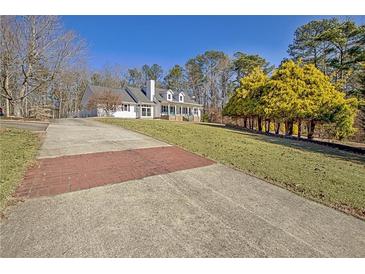 Spacious front yard with long driveway, lush landscaping, and mature trees at 4320 Chapel Hill Farms Dr, Douglasville, GA 30135