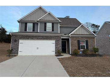 Two-story brick home with gray accents and a large driveway at 132 Oliver Dr, Locust Grove, GA 30248