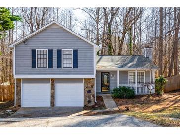 Gray house with white two-car garage and landscaped yard at 3276 Rollingbrook Way, Duluth, GA 30096