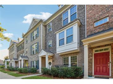 Brick townhouses with gray stone accents, landscaping, and red front doors at 1184 Warner Park Ct, Decatur, GA 30033