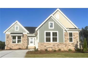 Charming new construction home with a stone and siding exterior and manicured lawn at 14 Cambridge Ln, Dallas, GA 30157
