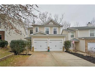 Tan two-story house with a double-car garage and manicured landscaping at 125 Hidden Creek Dr, Canton, GA 30114