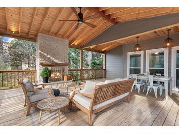 Relaxing covered back porch with fireplace and seating area at 2085 Melrose Trce, Cumming, GA 30041