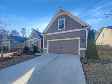 Two-story house with gray siding, two-car garage, and a paved driveway at 3338 Carolina Wren Sw Trl, Marietta, GA 30060