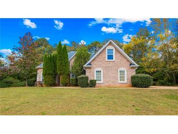 Brick house with a large front yard and mature trees at 101 Constance Dr, Locust Grove, GA 30248