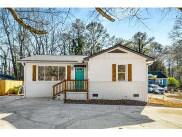 Charming ranch home with white brick exterior, teal door, and wood accents at 853 Hargis Se St, Atlanta, GA 30315