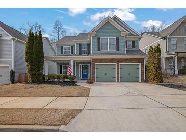 Two-story house with green siding, stone accents, and a three-car garage at 555 Winder Trl, Canton, GA 30114