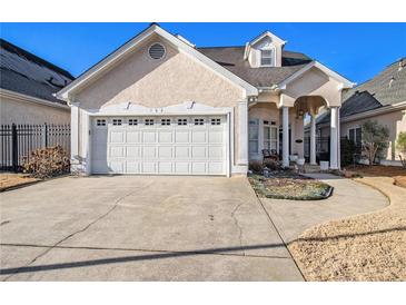 Charming home boasts a well-manicured lawn, a two-car garage, and a stucco exterior at 102 Prestwick S Way, Stockbridge, GA 30281