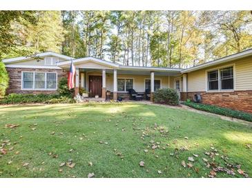 Ranch style home with stone accents, covered porch, and manicured lawn at 2886 Cardinal Lake Cir, Duluth, GA 30096