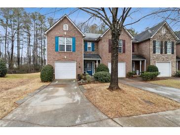 Brick townhome featuring colorful shutters and a well-maintained front yard at 245 Fern Crest Dr, Lawrenceville, GA 30046