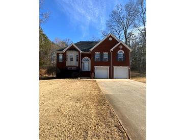 Brick house with two-car garage and a landscaped yard at 608 Morgans Trce, Ellenwood, GA 30294