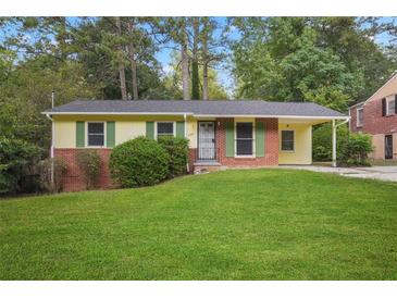 Brick ranch house with green accents, a covered carport, and a spacious lawn at 2907 Renfro Nw Dr, Atlanta, GA 30318