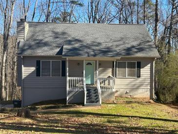 Charming ranch home with gray siding, light blue door, and a deck at 3973 Woodland Circle Se, Conyers, GA 30013