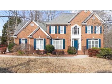 Two-story brick home with blue shutters and well-manicured landscaping at 305 Corrigan Trce, Peachtree City, GA 30269