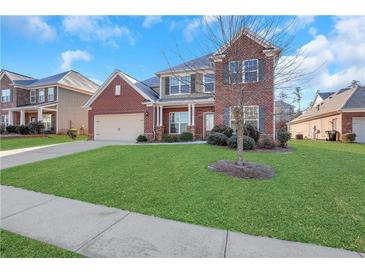 Brick two-story house with a large front yard and attached garage at 1209 Westgate Dr, Lilburn, GA 30047