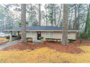 Charming single-story home with brick facade, black door, well-maintained landscaping, and a convenient carport at 2405 County Line Sw Rd, Atlanta, GA 30331