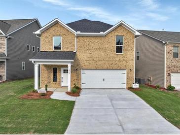 Two-story brick home with a large driveway and landscaping at 1862 Weatherbrook Cir, Lawrenceville, GA 30043