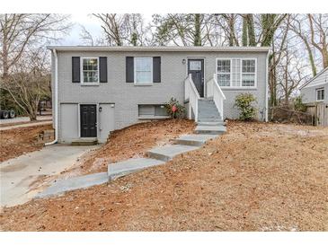 Gray brick ranch house with a gray door and steps leading to the entrance at 3164 Delmar Nw Ln, Atlanta, GA 30311