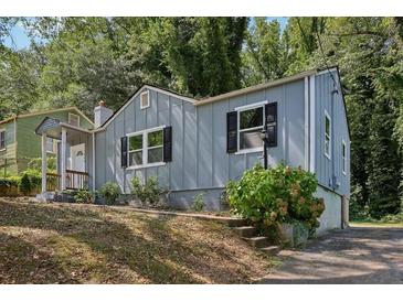 Charming gray house with black shutters, landscaped yard, and a driveway at 1626 Kenmore Sw St, Atlanta, GA 30311