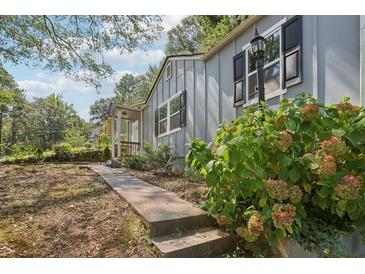 Charming home featuring a well-maintained yard and inviting walkway to the front porch at 1626 Kenmore Sw St, Atlanta, GA 30311