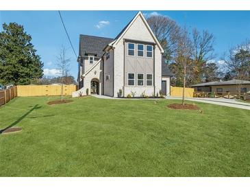 Two-story house with white brick exterior, gray accents, and a large grassy yard at 635 San Fernando Dr, Smyrna, GA 30080