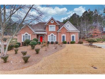 Brick house with red door, landscaping, and a large yard at 3640 Rolling Creek Dr, Buford, GA 30519