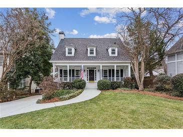 Two-story house with white exterior, front porch, and landscaped lawn at 975 Seaboard Nw Ave, Atlanta, GA 30318