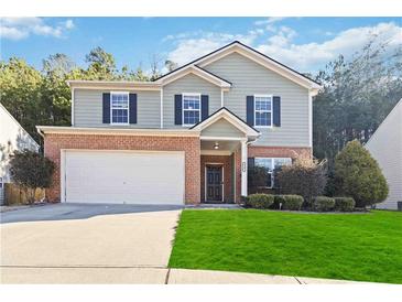 Two-story house with brick and siding, a large yard, and a two-car garage at 6397 Barker Station Walk, Sugar Hill, GA 30518