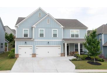 Two story house with light blue siding, three car garage, and landscaped yard at 121 Treeline Trl, Canton, GA 30115