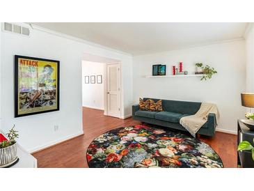 Bright living room with hardwood floors, stylish rug, and comfy couch at 6940 Roswell Rd # 16B, Atlanta, GA 30328